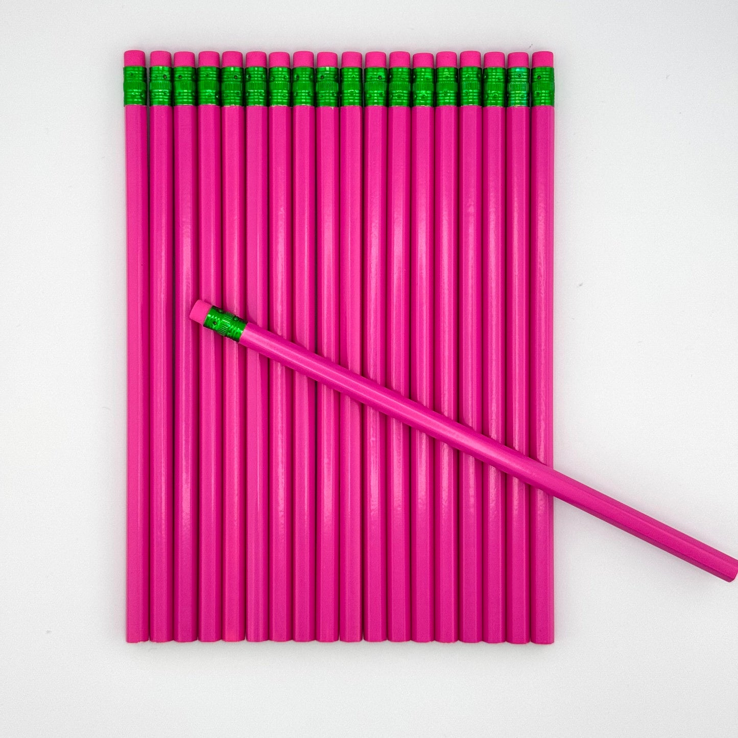 Pink pencils with pink erasers arranged on a white background