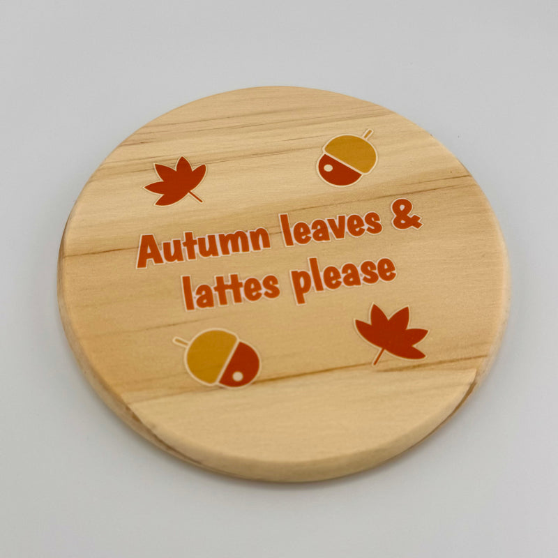Wooden coaster with autumn-themed design and text on a gray background