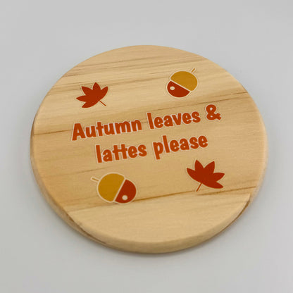 Wooden coaster with autumn-themed design and text on a gray background